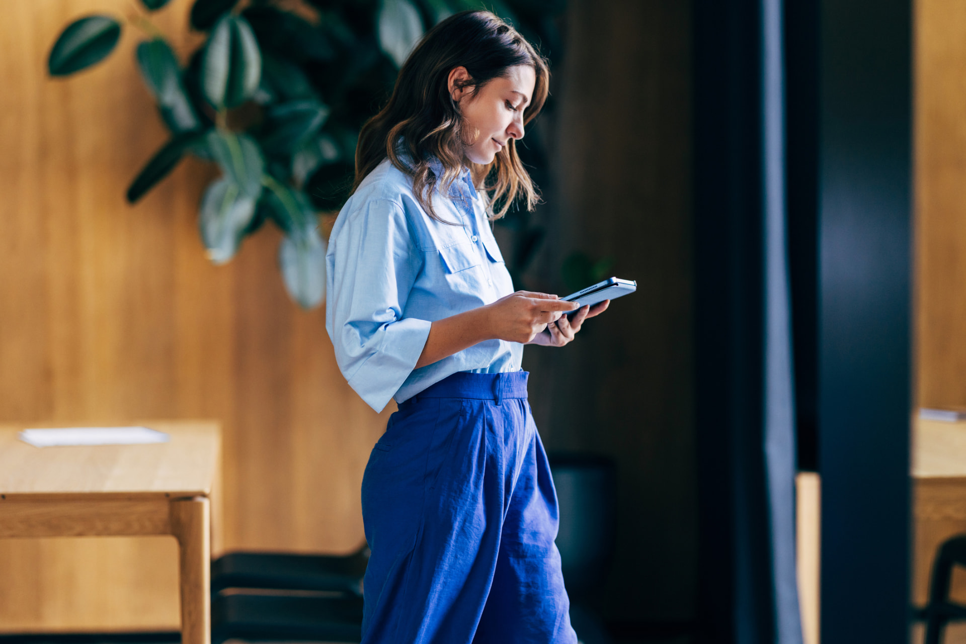 Woman walking outside with a tablet